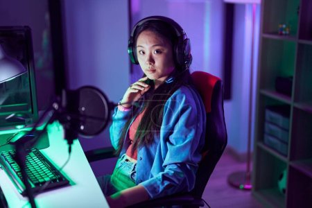 Foto de Joven mujer china streamer jugando videojuego utilizando la computadora en la sala de juegos - Imagen libre de derechos