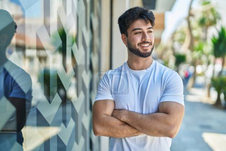 Téléchargez les photos : Young hispanic man smiling confident standing with arms crossed gesture at street - en image libre de droit