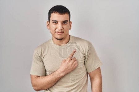 Téléchargez les photos : Jeune homme arabe portant t-shirt décontracté pointant de côté inquiet et nerveux avec index, expression préoccupée et surprise - en image libre de droit