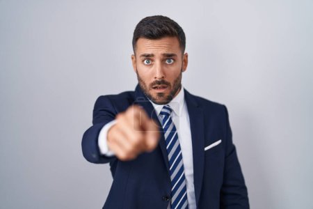 Photo for Handsome hispanic man wearing suit and tie pointing displeased and frustrated to the camera, angry and furious with you - Royalty Free Image
