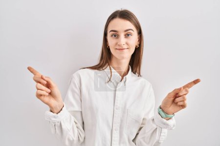 Téléchargez les photos : Jeune femme caucasienne debout sur fond isolé souriant confiant pointant avec les doigts vers différentes directions. espace de copie pour la publicité - en image libre de droit