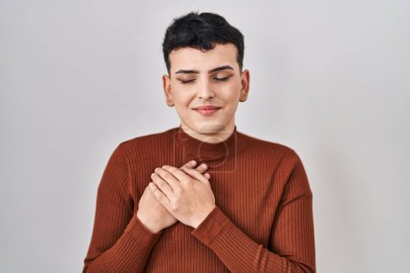 Photo for Non binary person wearing make up standing over isolated background smiling with hands on chest with closed eyes and grateful gesture on face. health concept. - Royalty Free Image