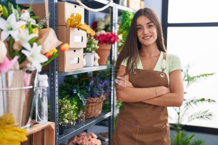 Photo for Young beautiful hispanic woman florist smiling confident standing with arms crossed gesture at flower shop - Royalty Free Image