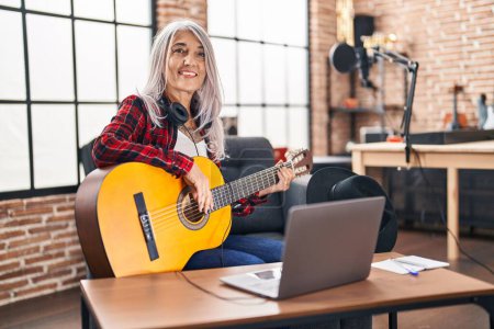 Téléchargez les photos : Femme musicienne aux cheveux gris du Moyen Âge jouant de la guitare classique au studio de musique - en image libre de droit