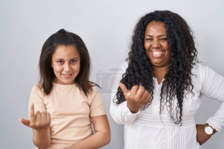 Téléchargez les photos : Mère et jeune fille debout sur fond blanc font signe de venir ici geste avec la main invitant accueillant heureux et souriant - en image libre de droit