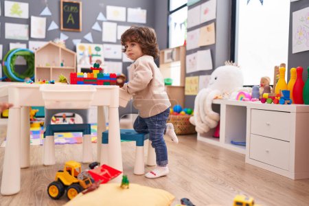 Photo for Adorable hispanic boy playing with construction blocks standing at kindergarten - Royalty Free Image