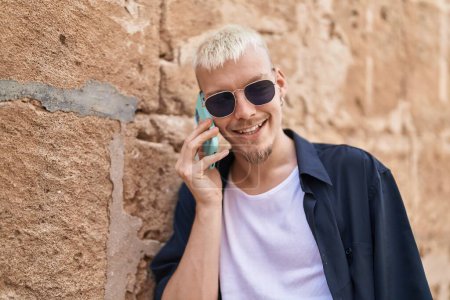 Foto de Young caucasian man smiling confident talking on smartphone at street - Imagen libre de derechos