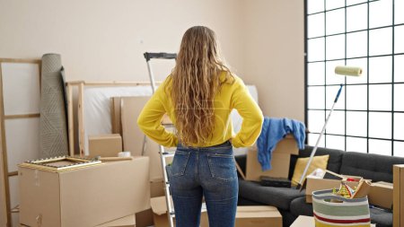 Téléchargez les photos : Jeune femme blonde debout vers l'arrière à la nouvelle maison - en image libre de droit
