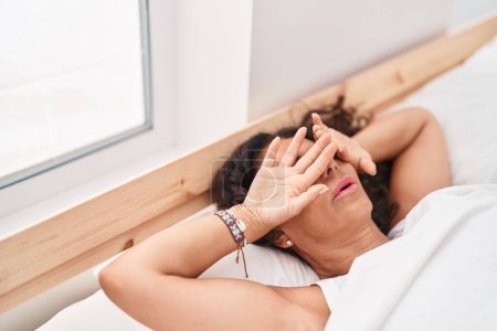 Téléchargez les photos : Femme d'âge moyen couchée sur le lit dormant dans la chambre - en image libre de droit