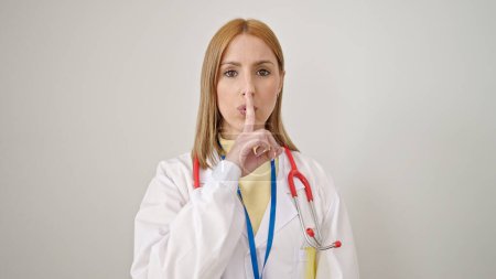 Téléchargez les photos : Jeune femme blonde médecin demandant le silence sur fond blanc isolé - en image libre de droit