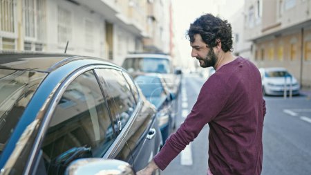 Foto de Young hispanic man opening car door at street - Imagen libre de derechos