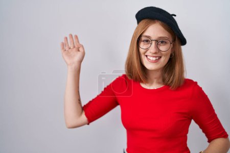 Téléchargez les photos : Jeune rousse femme debout portant des lunettes et béret dansant heureux et joyeux, souriant émouvant occasionnel et confiant écouter de la musique - en image libre de droit