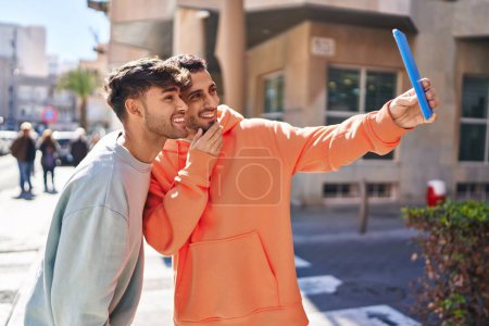 Foto de Dos hombre pareja hacer selfie por touchpad en la calle - Imagen libre de derechos