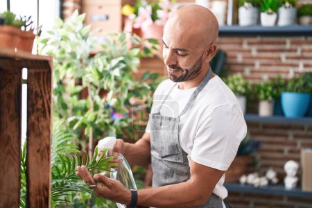 Téléchargez les photos : Young bald man florist using difusser working at florist - en image libre de droit