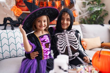 Photo for Adorable boy and girl having halloween party hugging each other at home - Royalty Free Image