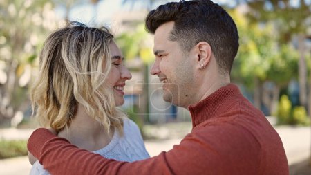 Téléchargez les photos : Man and woman couple smiling confident hugging each other at park - en image libre de droit