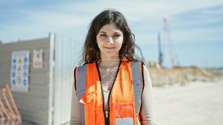 Téléchargez les photos : Jeune belle hispanique femme constructeur souriant confiance debout à la rue - en image libre de droit