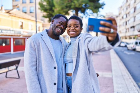 Foto de Hombre y mujer pareja de pie juntos hacer selfie por el teléfono inteligente en la calle - Imagen libre de derechos