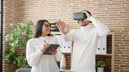Foto de Trabajadores de negocios de hombre y mujer usando touchpad y gafas de realidad virtual en la oficina - Imagen libre de derechos