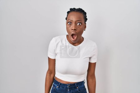 Photo for Beautiful black woman standing over isolated background in shock face, looking skeptical and sarcastic, surprised with open mouth - Royalty Free Image