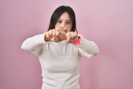 Téléchargez les photos : Femme avec le syndrome du duvet debout sur fond rose expression de rejet croisant les doigts faisant signe négatif - en image libre de droit