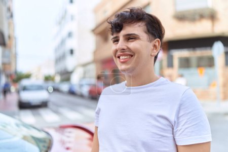 Téléchargez les photos : Non binary man smiling confident looking to the side at street - en image libre de droit
