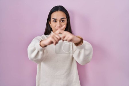 Foto de Joven sur asiático mujer de pie sobre rosa fondo rechazo expresión cruzando dedos haciendo negativo signo - Imagen libre de derechos
