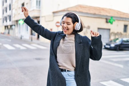 Foto de Mujer joven escuchando música y bailando en la calle - Imagen libre de derechos
