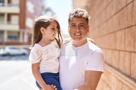 Foto de Padre e hija sonriendo confiados abrazándose en la calle - Imagen libre de derechos