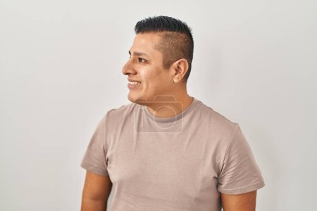 Téléchargez les photos : Jeune homme hispanique debout sur fond blanc regardant de côté avec le sourire sur le visage, expression naturelle. riant confiant. - en image libre de droit