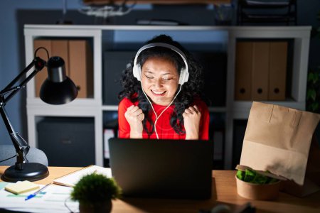 Photo for Young asian woman working at the office with laptop at night excited for success with arms raised and eyes closed celebrating victory smiling. winner concept. - Royalty Free Image