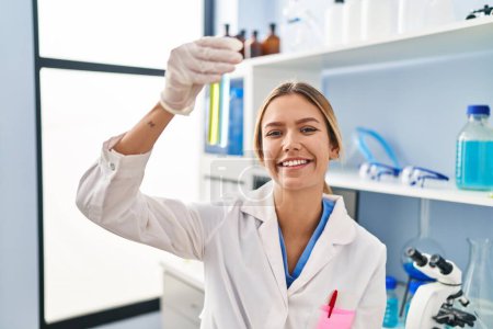 Photo for Young hispanic woman scientist holding test tubes at laboratory - Royalty Free Image