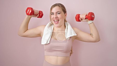 Photo for Young blonde woman wearing sportswear training with dumbbells over isolated pink background - Royalty Free Image
