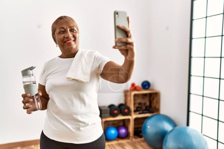 Foto de Senior mujer afroamericana sonriendo confiado hacer selfie por el teléfono inteligente en el centro deportivo - Imagen libre de derechos