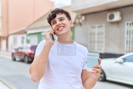 Téléchargez les photos : Homme non binaire parlant sur smartphone boire du café à la rue - en image libre de droit