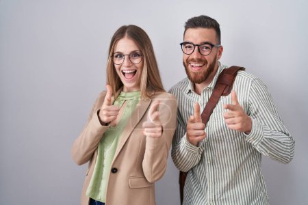 Photo for Young couple standing over white background pointing fingers to camera with happy and funny face. good energy and vibes. - Royalty Free Image