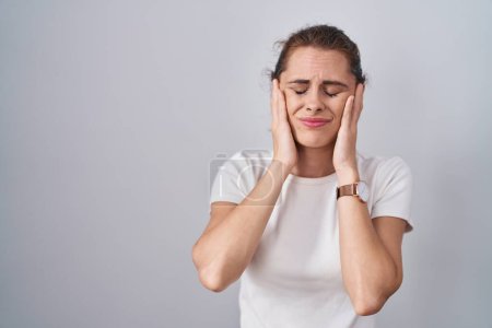 Téléchargez les photos : Belle femme brune debout sur fond isolé avec la main sur la tête, maux de tête parce que le stress. migraine souffrant. - en image libre de droit