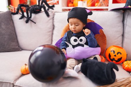 Foto de Adorable niño hispano con traje sosteniendo globo en casa - Imagen libre de derechos