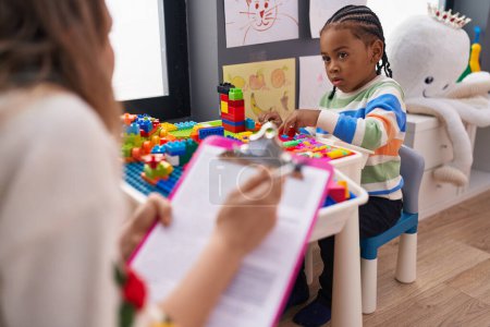 Foto de Chico afroamericano jugando con bloques de construcción que tienen psicoterapia en el jardín de infantes - Imagen libre de derechos