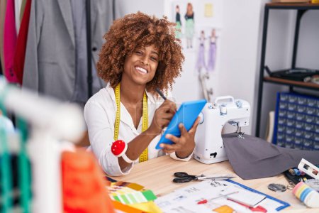 Téléchargez les photos : Femme afro-américaine tailleur sourire dessin confiant sur pavé tactile à l'atelier - en image libre de droit