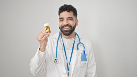 Photo for Young hispanic man doctor holding pills over isolated white background - Royalty Free Image