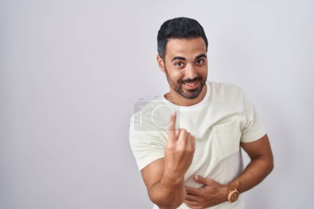 Téléchargez les photos : Un homme hispanique avec la barbe debout sur un fond isolé fait signe de venir ici geste avec la main invitant accueillant heureux et souriant - en image libre de droit