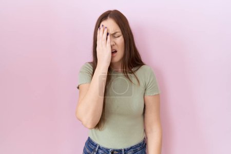 Photo for Beautiful brunette woman standing over pink background yawning tired covering half face, eye and mouth with hand. face hurts in pain. - Royalty Free Image