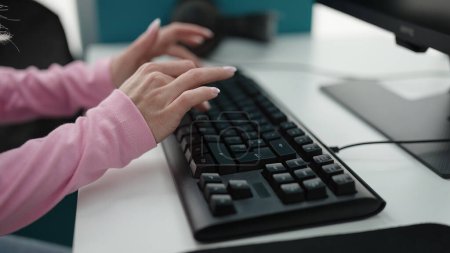 Téléchargez les photos : Young blonde woman student using computer studying at library university - en image libre de droit