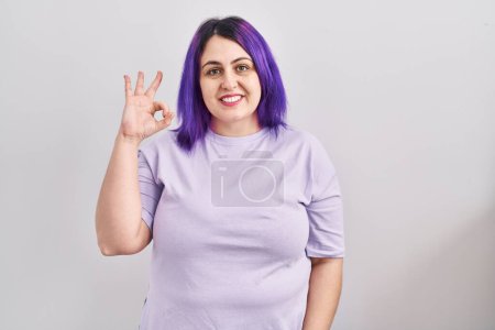 Téléchargez les photos : Plus taille femme avec les cheveux violets debout sur fond isolé souriant positif faire ok signe avec la main et les doigts. expression réussie. - en image libre de droit
