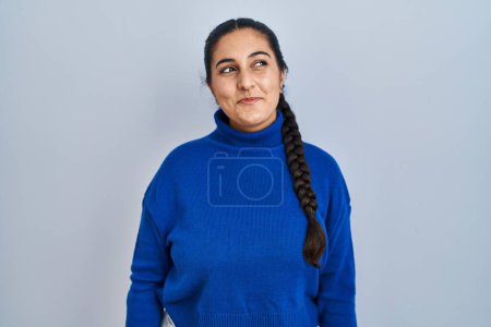 Téléchargez les photos : Jeune femme hispanique debout sur fond isolé souriant regardant vers le côté et regardant loin en pensant. - en image libre de droit