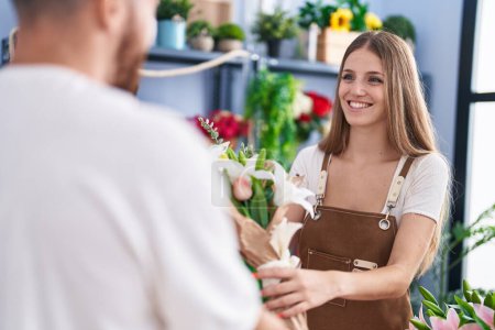 Téléchargez les photos : Man and woman customer buying bouquet of flowers at flower shop - en image libre de droit