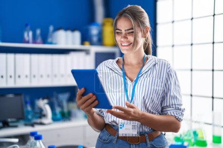 Téléchargez les photos : Young woman scientist using touchpad working at laboratory - en image libre de droit