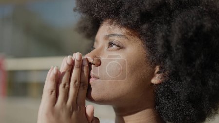 Téléchargez les photos : Femme afro-américaine priant dans la rue - en image libre de droit