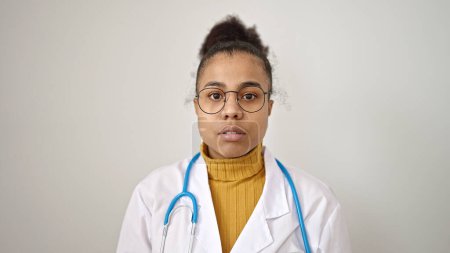 Photo for Young african american woman doctor standing with serious expression over isolated white background - Royalty Free Image